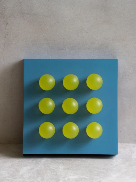 Portofino by Paola del Valle — a teal-blue square panel set with a three-by-three grid of nine chartreuse-yellow orbs.